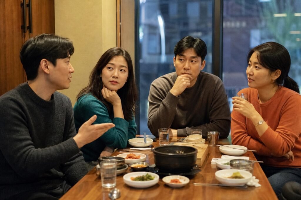 Four Korean adults noticing subtle social cues during a conversation at a restaurant